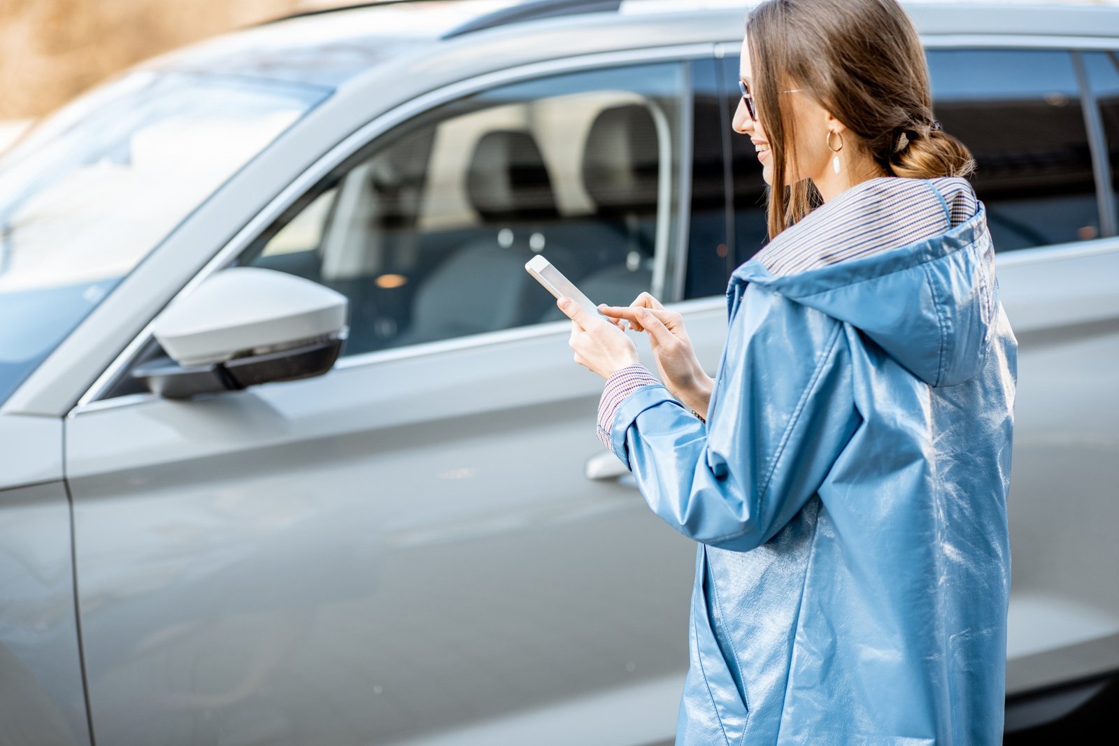 Woman controlling car through the smartphone